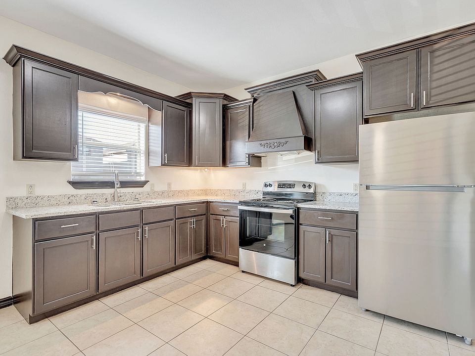 Chic kitchen showcasing stainless steel appliances and stylish gray cabinets in the luxurious Merida Vista Apartments, Laredo, Texas
