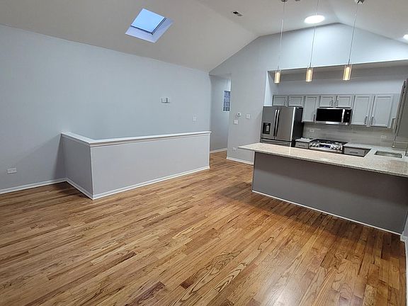 A spacious eat-in kitchen and living room area. The Skylight bath the whole area with natural sunlight.