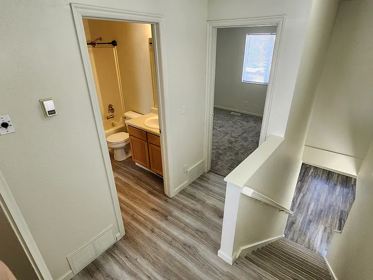 View into upstairs bathroom, 2nd bedroom, and stairway down to living room