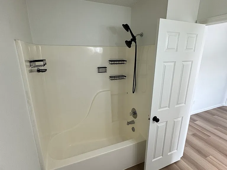 Primary bathroom shower/tub combo with clean, updated finishes.