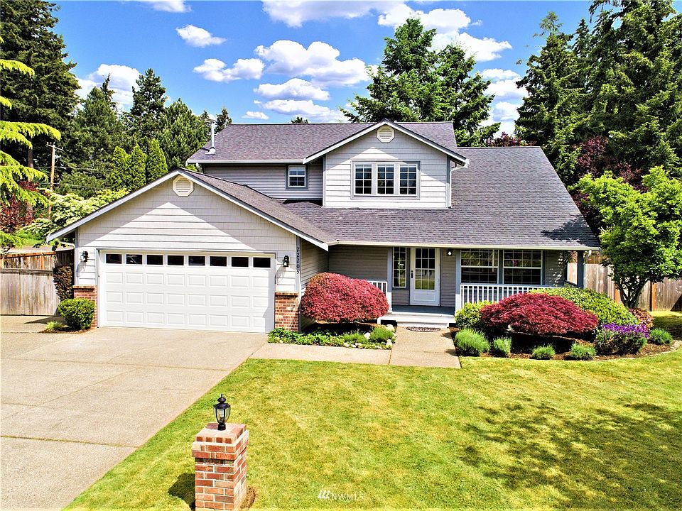 Front view of great home with large front porch, mature landscaping and extra parking on the left
