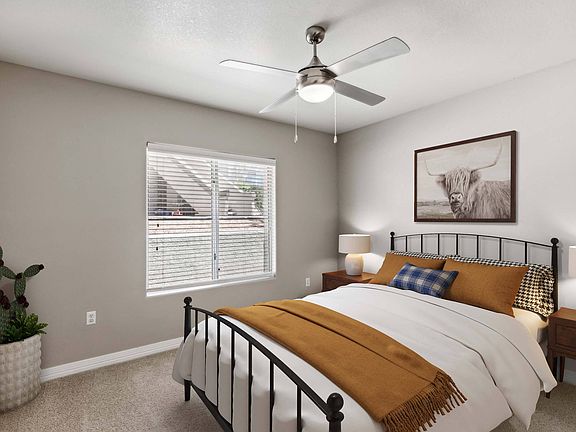 Bedroom with ceiling fan and plush carpeting