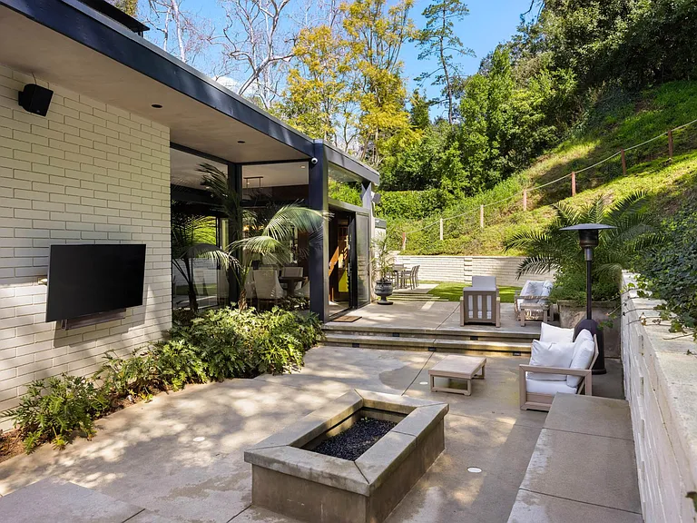 Immerse yourself in the ambiance of the outdoor seating area, complete with a captivating fire pit and an outdoor Smart TV.