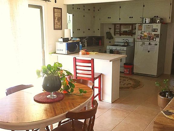 Dining room, kitchen, and sliding glass door.