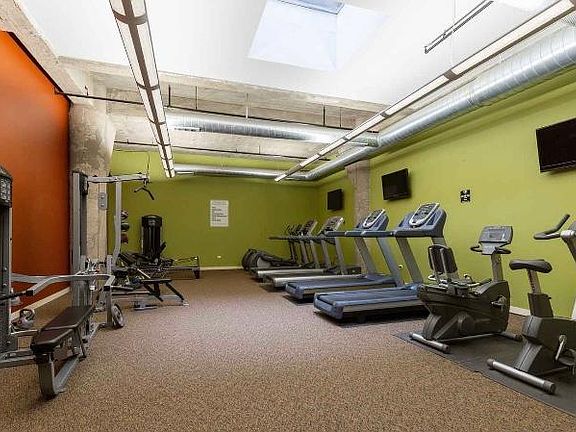 Fitness center with cardio equipment, machines and free weights.