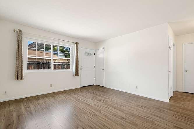 Living room view showing front door and guest closet, and small hallway