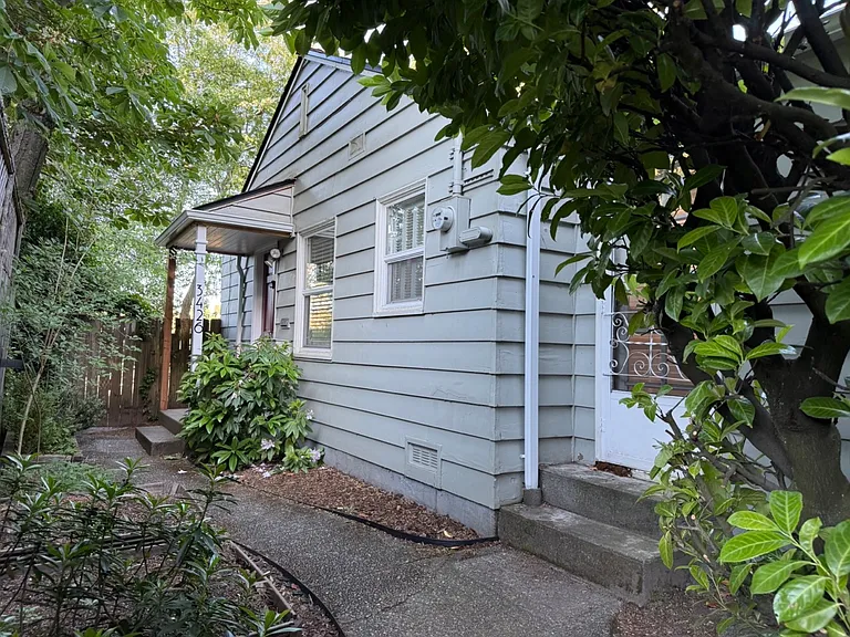 Take the stairs or the winding path from street level down to the front of the house.