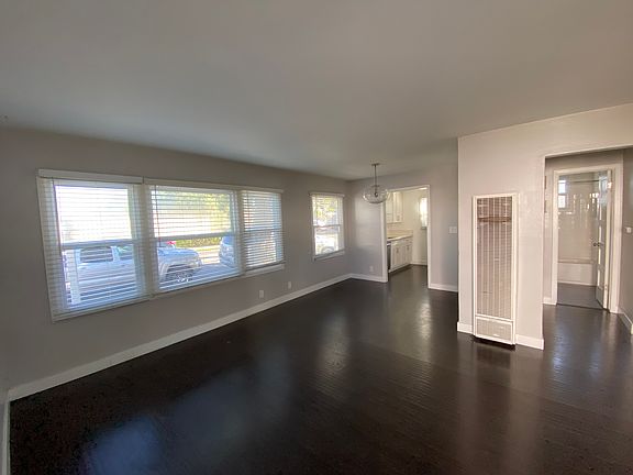 View of Living and Dining Room, Wall Heater, View into Bedroom Entries and Bathroom