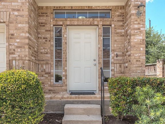 Brick home with front entrance and landscaping; home has 3 ac units to allow for efficient cooling and heating on each of the 3 floors;