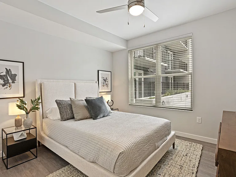 Spacious Bedroom With Ceiling Fan And Large Windows