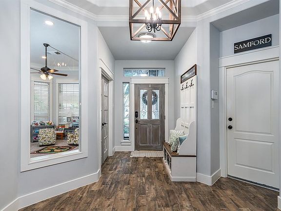 Inviting entry with mahogany leaded and beveled glass door and custom barnwood chandelier.