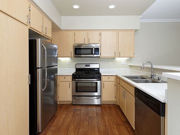 Kitchen with stainless steel appliances, laminate countertops, oak cabinetry, and hard surface flooring