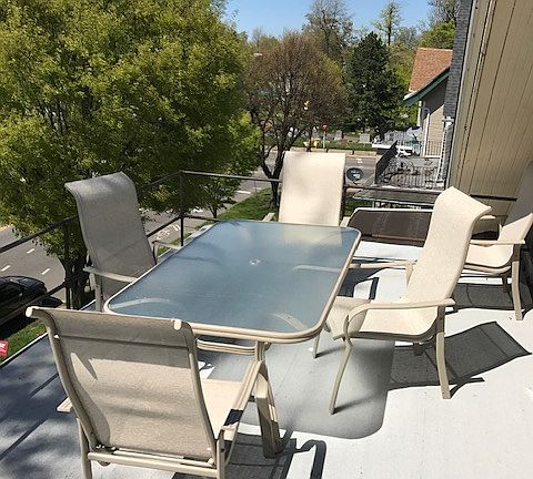 front porch with furniture overlooking tree lined Linwood Ave. and cemetery