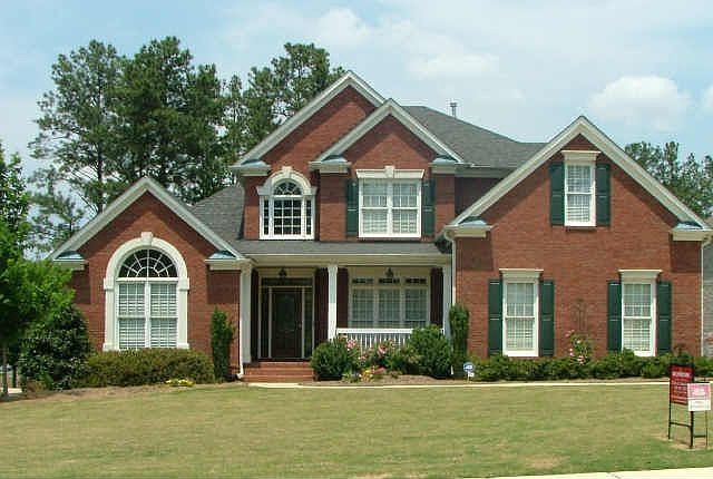 Three sided brick home with three car garage 