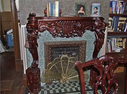 This decorative fireplace has an extensively detailed wood mantel