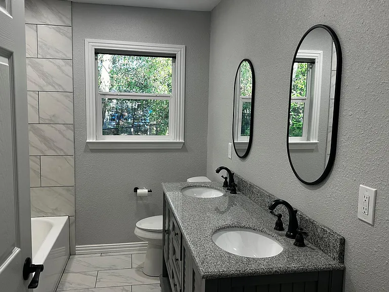 Renovated hallway bathroom includes shower/tub combo.
