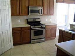  STAINLESS APPLIANCES IN KITCHEN, CORIAN COUNTERS, TILE BACKSPLASH & TILE FLOORS.