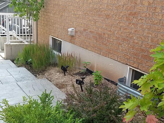 Patterned Concrete high end beautiful staircase/pathway leading to basement. Professionally landscaped with high end solar lights (right side view). Motion sensor floodlights are also installed in the pathway in addition to a a dozen solar lights to provi