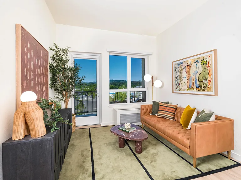 A bright living area at Modera Beaverton with balcony access, curated finishes, and a comfortable layout designed for everyday living and hosting.