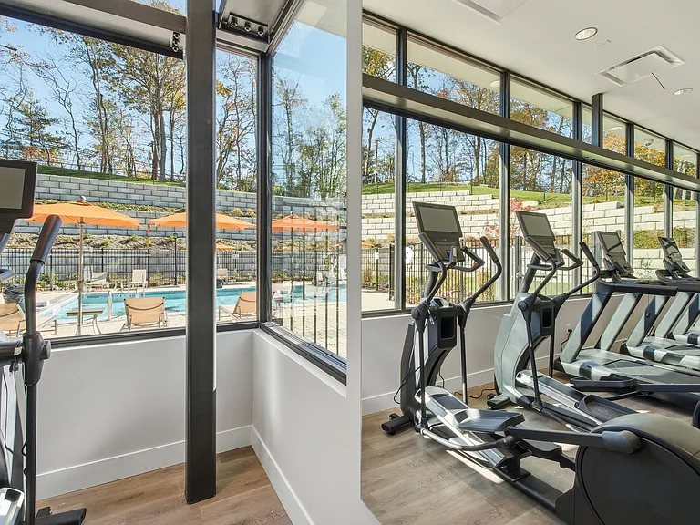 Elevate your lifestyle at Eagle Rock Apartments at Woodbury with our state-of-the-art fitness center featuring expansive views of the pool area. Embrace wellness in a vibrant community. Schedule your visit today!