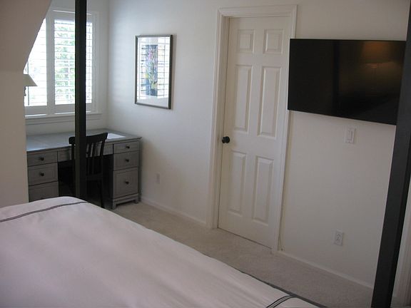 The work/desk area. The door opens to the walk-in closet and a large dresser is out of view to the right along with a door that opens onto a hallway going out to the living room and kitchen.