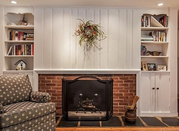 Formal living room offers wood burning fireplace, built ins and pegged hardwood floors.