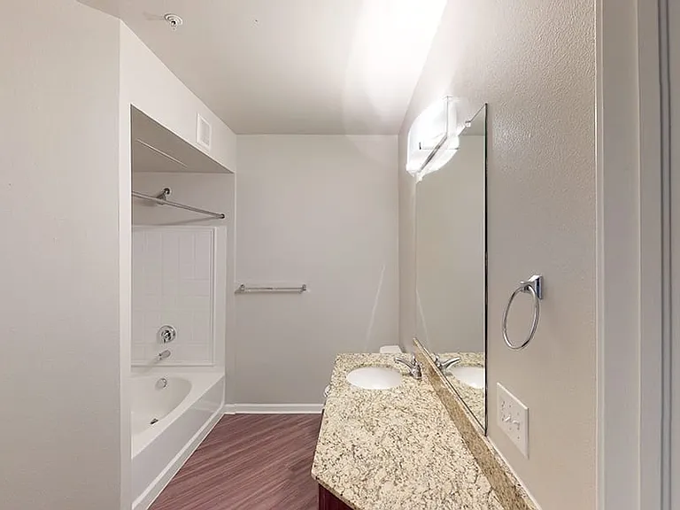 Apartment bathroom with wood-style flooring.