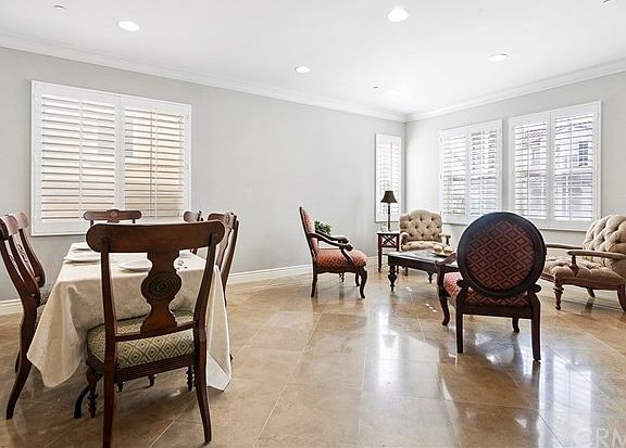Notice the beautiful plantation shutters, recessed lighting, upgraded baseboards, crown moulding and travertine tile floor throughout.