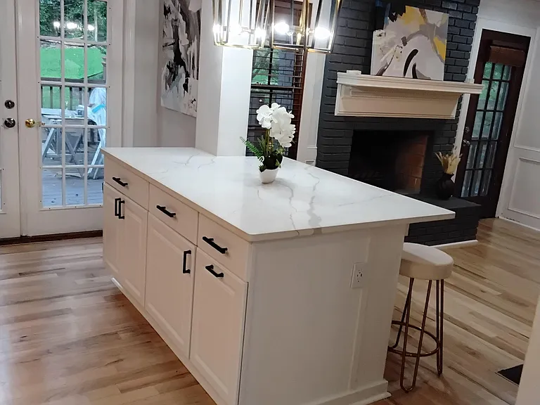 Kitchen features a large island with quartz-style counters, pendant lighting, and easy access to the outdoor deck.
