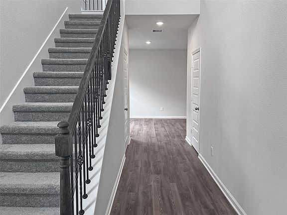 The Sparrow II- Entry staircase with wrought iron railing. Home under construction. Sample floor pl