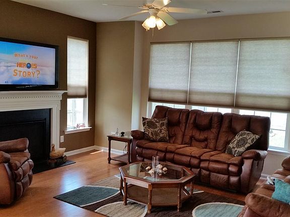 Enjoy entertaining in this open concept living space.  Fireplace with mantle, shades, and ceiling fan.