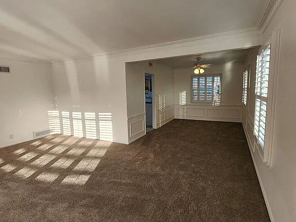 Spacious living and dining room with beautiful shutter windows making both rooms airy and bright.