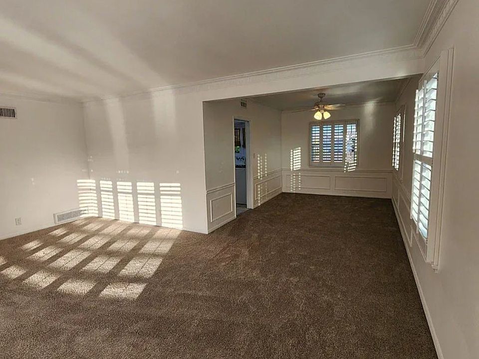 Spacious living and dining room with beautiful shutter windows making both rooms airy and bright.