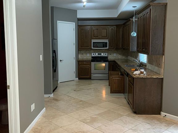 Kitchen right before the refrigerator in this picture is the entry from the garage. The other open door is the powder room