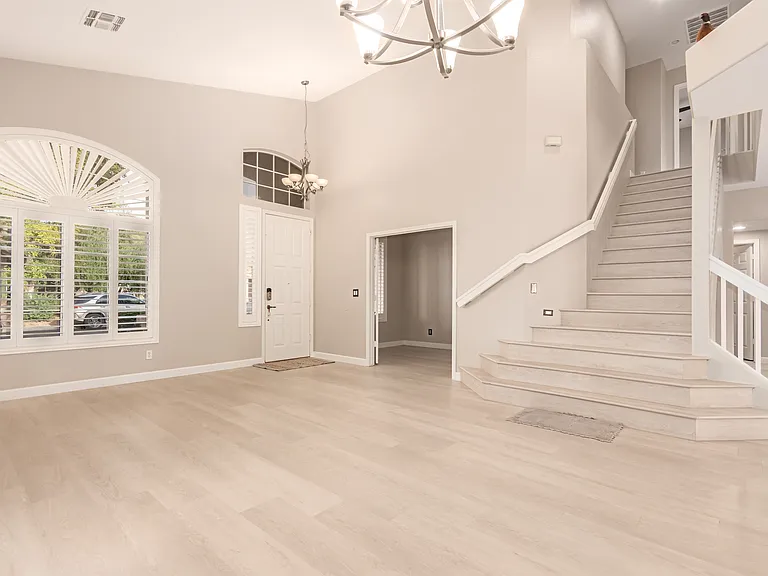 Main Entrance Opens to a Bright Living Room with Stairs Leading to the Upstairs Primary Bedroom and Two Additional Bedrooms.