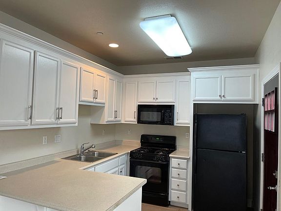 Kitchen with room for bar stools at the counter. Dishwasher, garbage disposal, range, microwave & frig.