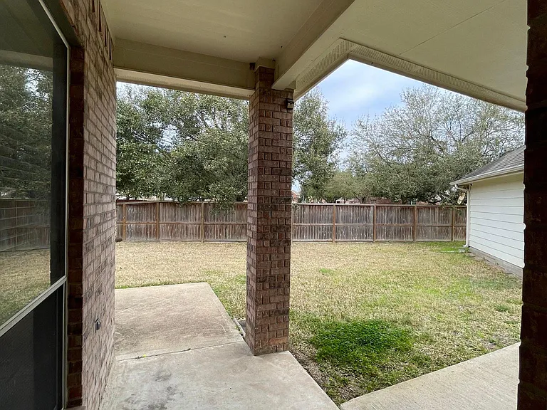 Covered patio overlooking the spacious backyard, perfect for relaxing or entertaining