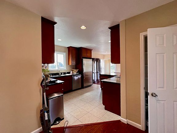 View of kitchen and pantry (door open) from living room