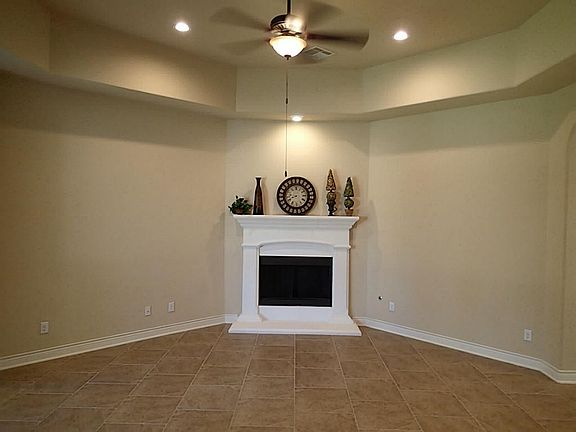 Open family room with cast stone fireplace & coffered ceilings.