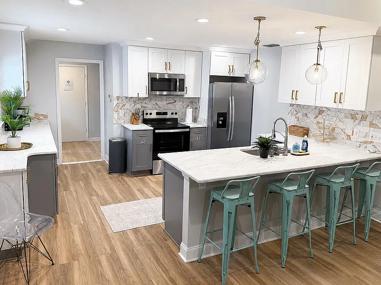 Updated kitchen with island seating, stainless appliances, and ample cabinetry for shared cooking and storage.