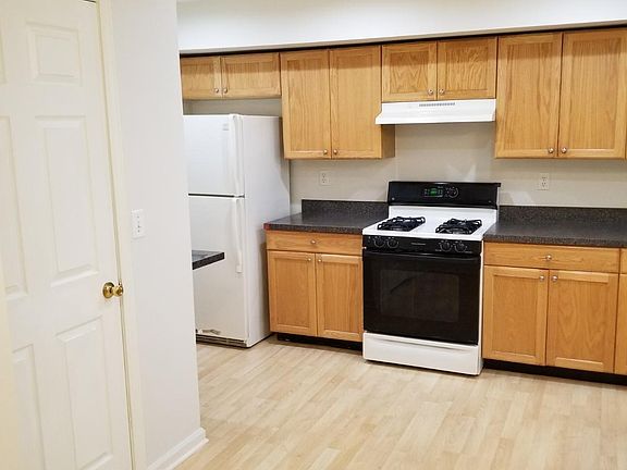 Kitchen view 1 with refrigerator, stove, cabinets and full size pantry.
