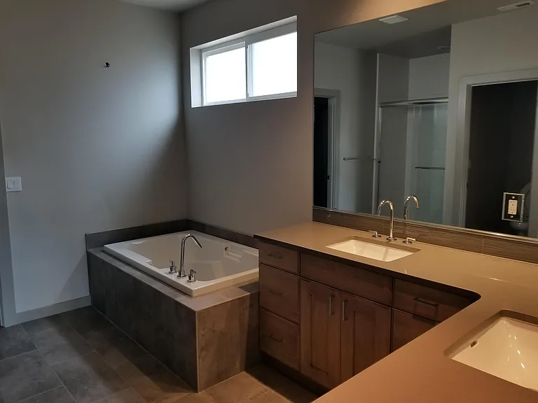 Spacious master bath has dual sinks, quartz countertops, deep soaking tub.