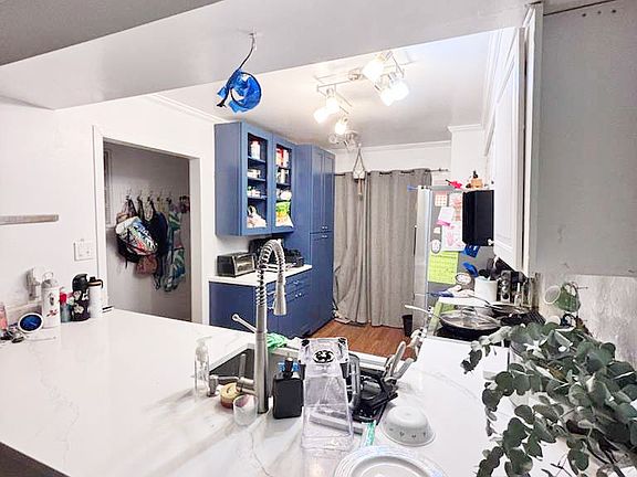 Kitchen viewed from the dining room. White marble countertop and storage. / Cocina desde el comedor. Marmol blanco en la cubierta y muebles de almacenamiento.
