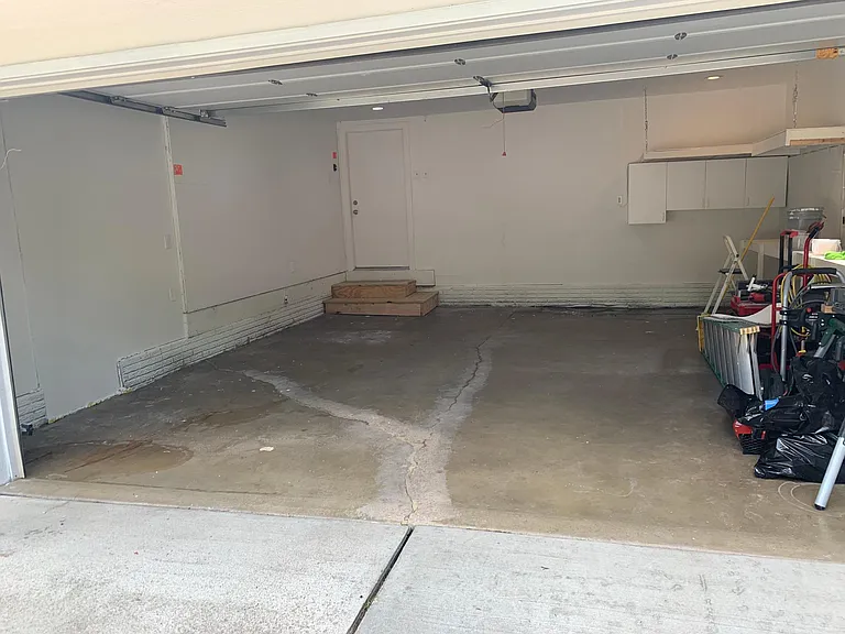 Two car garage with shelving and cupboards. Newly painted with new drywall and new lighting