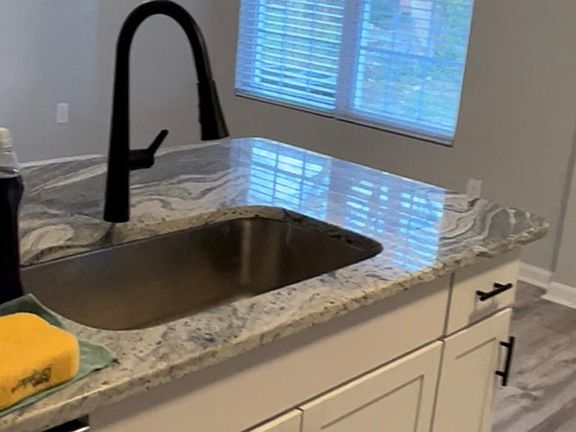 Kitchen to family room. New blinds throughout. Check out the light inside the faucet!