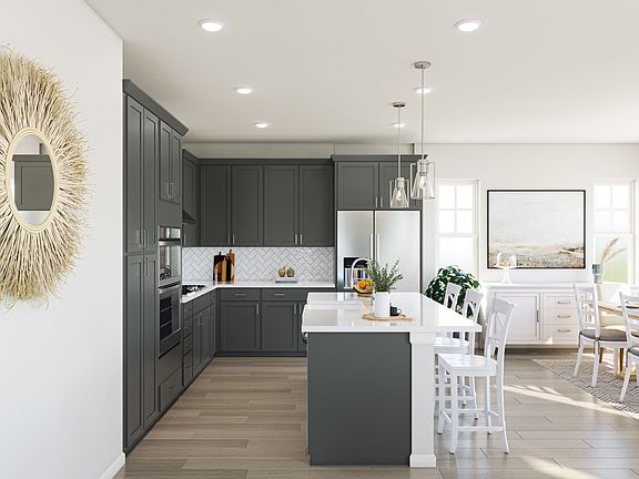 A modern, open-concept kitchen with dark gray cabinets, a white island, and pendant lighting, set ag
