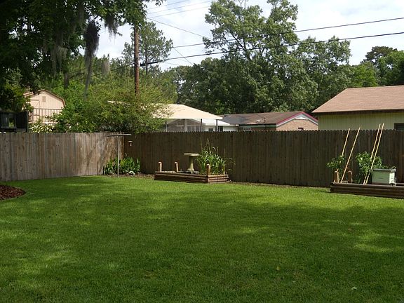 LUSH, LANDSCAPED YARD WITH PRIVACY FENCED AND WOODEN PLANTERS