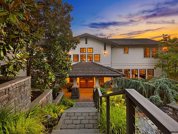 Sweeping stairs down to the veranda, flanked by a waterfall and beautiful mater landscaping