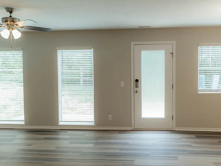 Living/Dining has lots of South windows with wood blinds, neutral decor, and Luxury Vinyl Plank for low maintenance living.
