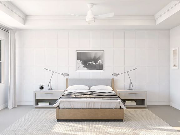 Primary suite with decorative feature wall and tray ceiling with crown moulding